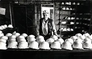 00327 Prints: Coal - Miners - Coal miner checks the miners hats at a South Wales Colliery