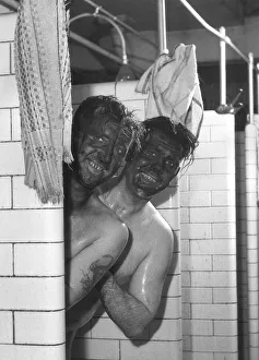 Miners Prints: Coal miners John Derbyshire front and Vinc Higson give each other assistance to get clean