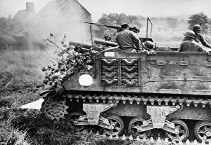 01441 Prints: One of a column of camouflaged M7 tanks blasts away with another round at German