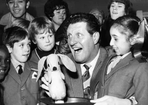 Comedian and magician Tommy Cooper pulls a rabbit out of the hat during a demonstration