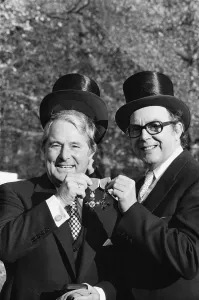 Comedians Morecambe and Wise seen here showing off their medals outside Buckingham Palace