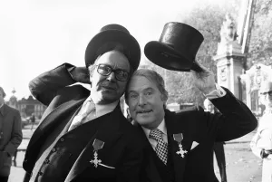 Comedians Morecambe and Wise seen here showing off their medals outside Buckingham Palace