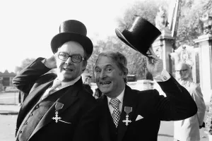 Comedians Morecambe and Wise seen here showing off their medals outside Buckingham Palace