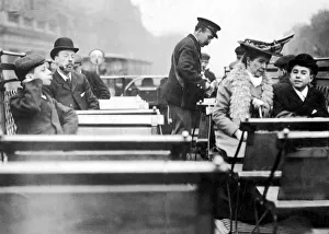Lottery Prints: A conductor checks for passengers tickets on the open top deck of a London tram