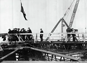 Construction of the new Tyne Bridge. Hoisting the Union Jack on the top after the joining