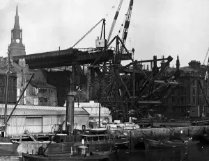 Construction of the new Tyne Bridge. The Tyne Bridge is a through arch bridge over