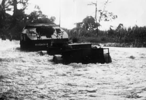 A convoy of British 25 pounders navigate a flooded section of road on their way up