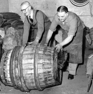 Coppers pushing a finished barrel made by an apprentice to mark the end of his five year