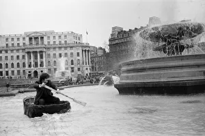 Coracle fishermen in London. One of the fishermen paddles his coracle round Trafalgar