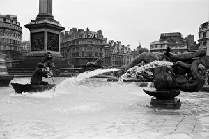 00967 Prints: Coracle fishermen in London. One of the fishermen paddles his coracle round Trafalgar