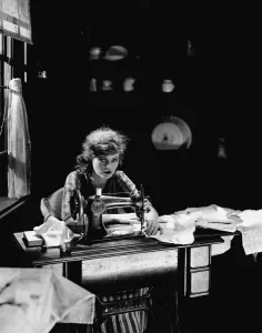 One Young Woman Only Prints: Corinne Griffith seen here in the role of Mary Boyne sitting working at a Singer sewing