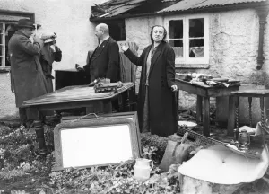 Cottagers in a South Western area survey the few salvaged possessions after their home