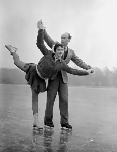00157 Prints: A couple ice skating on a frozen lake in winter January 1954