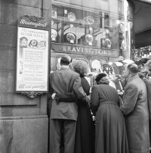 Couple looking at engagement rings in the window of Bravingtons in Fleet Street