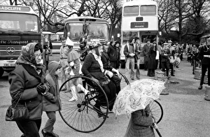 A couple ride their victorian tandam tricycle in the Easter parade, Battersea Park