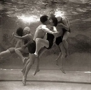 Underwater Prints: Couples searching for privacy beneath the waters of the swimming pool steal a shy kiss