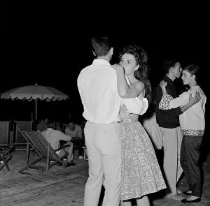 Couples slow dancing on the dancefloor of a bar in the French Riviera