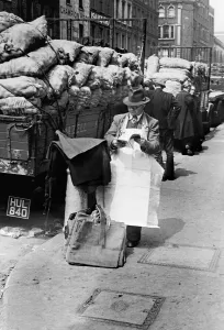 Century Prints: Covent Garden Market stall vendor stops to read a magazine. Circa 1955
