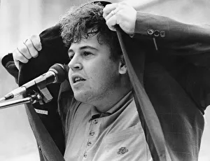 Coventry nurse Mark Rattray, takes cover from the rain during his performance at a