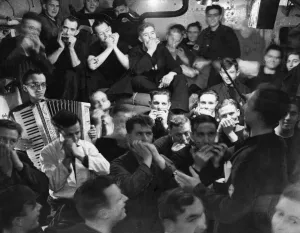 Musical Instruments Prints: The crew of HMS Haarlem celebrate below decks after sinking a German U-boat Circa August
