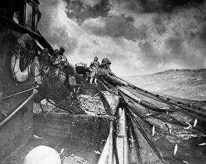 Clouds Prints: The crew of a Yarmouth Herring boat pull in their catch on a storm tossed North Sea