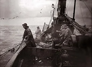 The crew of a Yarmouth Herring boat pull in their catch on a storm tossed North Sea