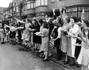 Crowd distributes food and drink to troops leaving for France during WW2 1944