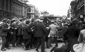 Crowds cheering Prime Minister Herbert Asquith as he returns from parliament following