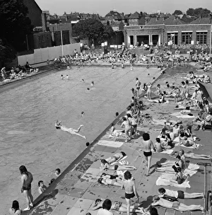 00804 Prints: Crowds of sunbathers at the Twickenham outdoor swimming pool, London. 7th June 1975