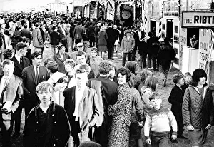 Curious crowds pass the sideshows at the Hoppings in 1965 at Newcastle Town Moor