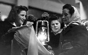 Electricity Prints: A customer in the Newcastle Grainger Market examines a rain coat by the lift of an oil
