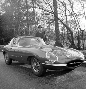 Daily Herald motor racing correspondent HThomas H Wisdom standing beside a new Jaguar