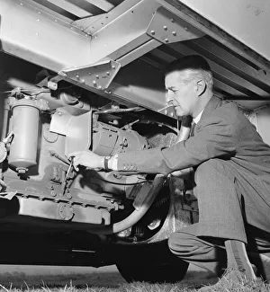 Daily Herald motor racing correspondent Thomas H Wisdom checks the engine of a Rolls