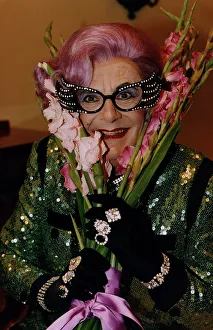 Dame Edna Everage Barry Humphries gladioli gladioluses purple hair large glasses black