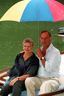 DAME JUDi DENCH & GEOFFREY PALMER (HOLDING UMBRELLA) SEATED IN ROWING BOAT DURING FILMING