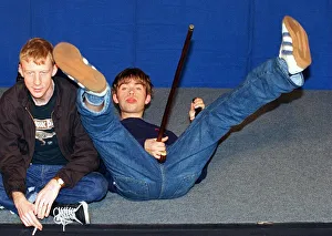 Damon Albarn lead singer of the pop group Blur lying on the floor holding a walking stick