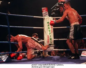 Daniel Jiminez of Puerto Rico punches Drew Docherty of Scotland through the ropes
