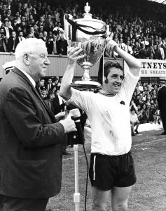 00239 Prints: Dave Mackay of Derby holding up the Watney Cup after Derby beat Manchester United
