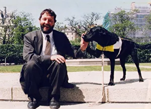 01427 Prints: David Blunkett sitting outside Houses of Parliament with guide dog 26 / 05 / 1994