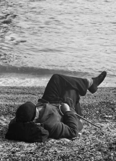 Holidaymaker Prints: A day-tripper from Londons East End, relaxes in the summer sunshine on the beach