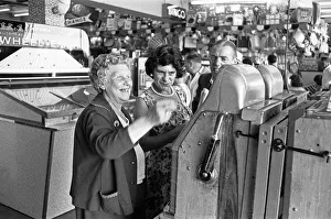 Holidaymaker Prints: Day trippers from Londons East End seen here playing the one armed bandits in an
