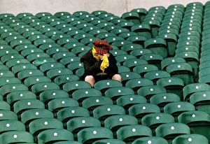 00198 Prints: A dejected Scotland fan sits in a stadium with his head in his hands after his teams