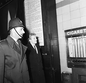 Meeting Prints: Denis Law escorted to the train at Victoria Station in Sheffield by a policeman following