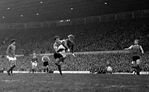 Denis Law of Manchester United beats a Sheffield Wednesday defender to fire a shot in