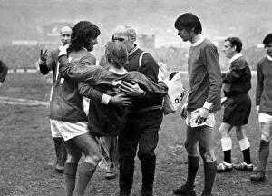 Denis Law of Manchester United being carried off the pitch after an injury