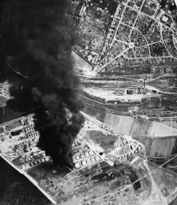 Mission Prints: A dense plume of acrid black smoke rising several thousand feet marks a burning oil tank