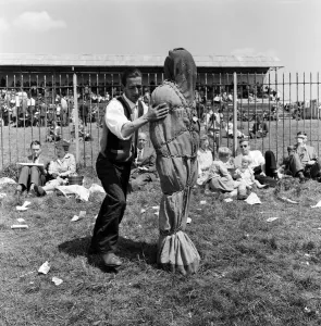 Heat Prints: Derby Day at Epsom. Pictured, a strong man wrapped in chains. 3rd June 1959