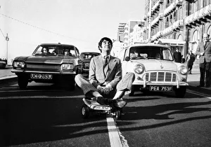 00144 Prints: Derek Nimmo actor in Brighton riding a toy car dbase msi
