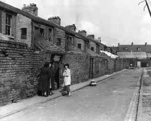 00054 Prints: Derelict housing in an area of Newcastle - A group of women gossip in the back lane