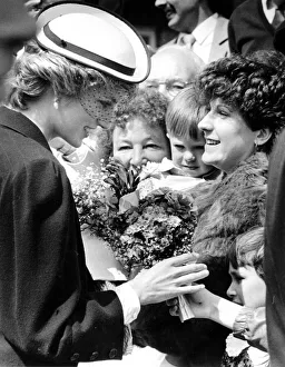 Diana, Princes of Wales receives a bouquet from an adoring well-wisher in the crowd